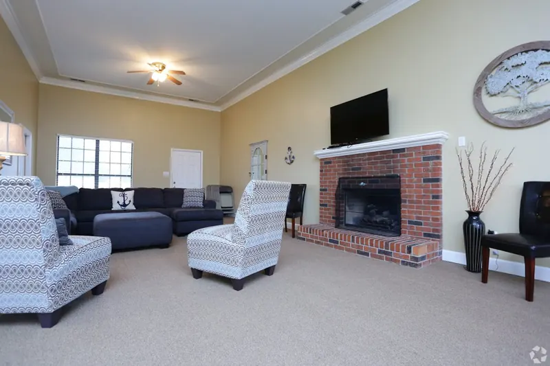 Clubroom lounge with a brick fireplace and TV